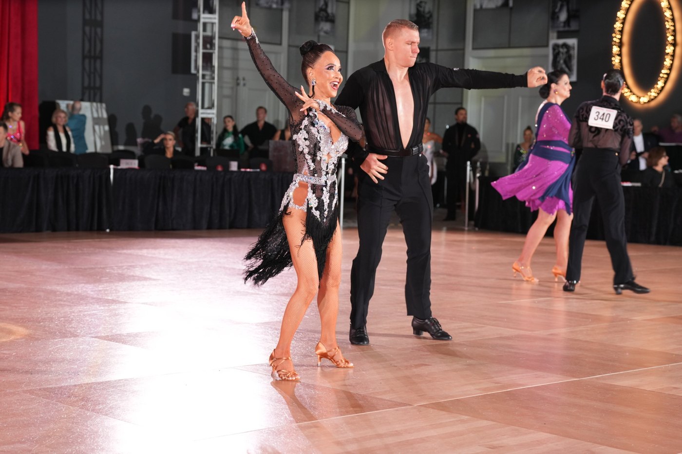 Our dancers on the competition floor — a couple dancing, smiling